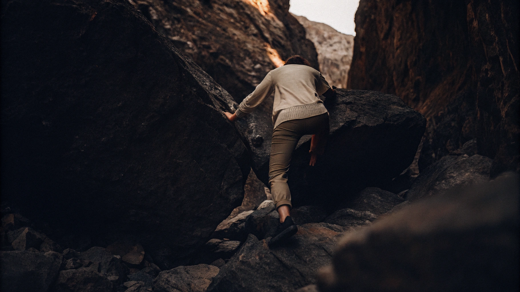 Someone Climbing Over Boulders On A. Mountain Pass. Identifying The Route To Making A Change